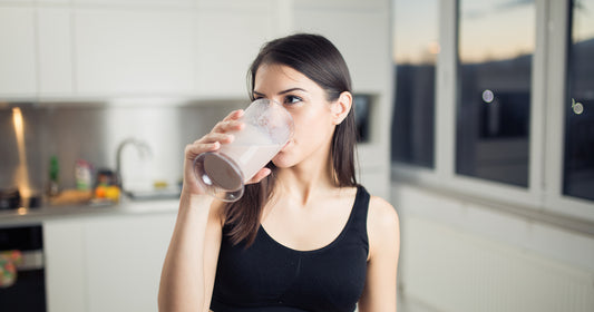a woman is drinking smoothie after workout