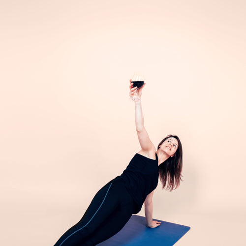 a woman is holding a wine glass and working out