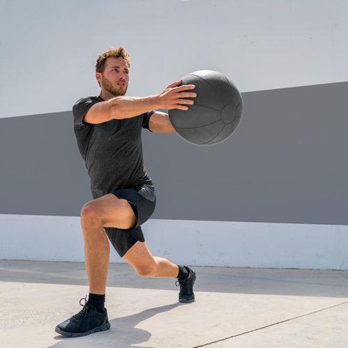 a man holding a ball is squatting