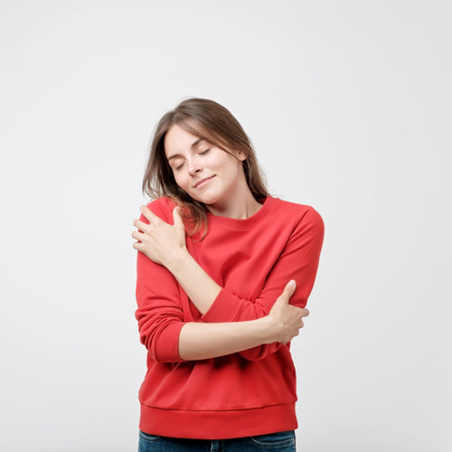 a woman is hugging herself