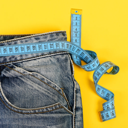 a scale on jeans on the yellow background